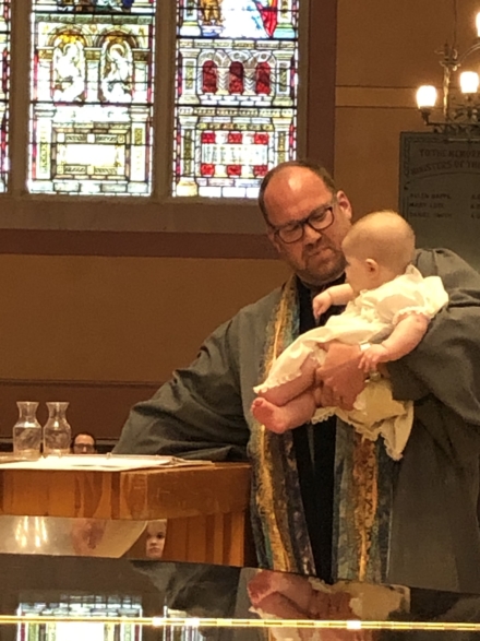 man baptizing a baby